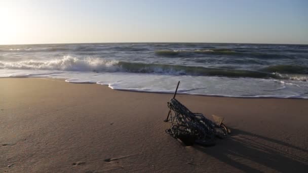 Âncora no litoral arenoso, na luz de fundo do sol. Capa do mar — Vídeo de Stock