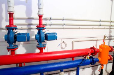 Kazan dairesinde ısıtma sistemi. Güçlü pompalar kırmızı ve mavi tüpler boru