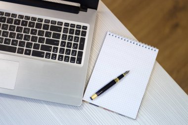 Bilgisayarlı ofis masası, not defteri, kalem. İş akışı. Yukarıdan görünüm.