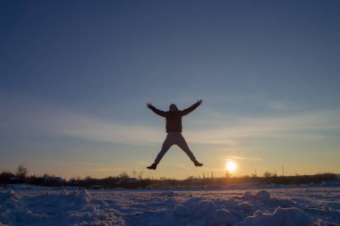 Günbatımı geçmişiyle atlayan adamın silueti, mutluluk konsepti, neşe, neşe dolu hayat
