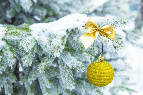 Schöne Gelbe Weihnachtskugel Auf Schneebedeckten Tannenzweigen Hintergrund Weihnachten — Stockfoto