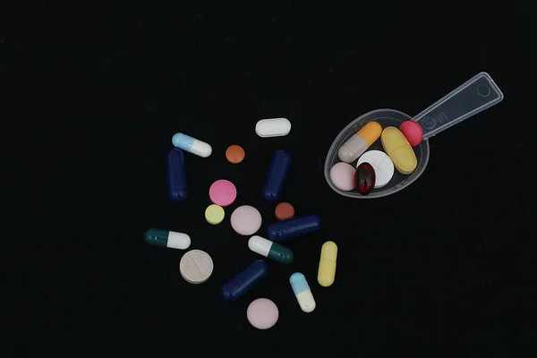 Cápsulas Multi Coloridas Pílulas Com Dispensador Colher Fundo Preto — Fotografia de Stock