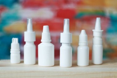 bulanık bir arka planda rinitin tedavisi için beyaz bir şişede burun damlaları