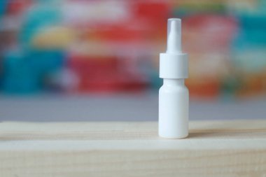 bulanık bir arka planda rinitin tedavisi için beyaz bir şişede burun damlaları