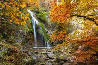 Kırım Dağları'nda sonbahar ormandaki güzel şelale. Su yosun taşlarla. Bulanık su. Şelale Jur-Jur - Crimea yarımadanın doğal Simgesel Yapı Ulu-uz Nehri üzerinde yer alan