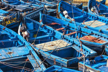 Essaouira, Fas - 20 Kasım 2018: Mavi balıkçı tekneleri limanda güneşli bir gün, sur duvarları ve Mogador, bir ülkenin konumlar kalesinin Kulesi