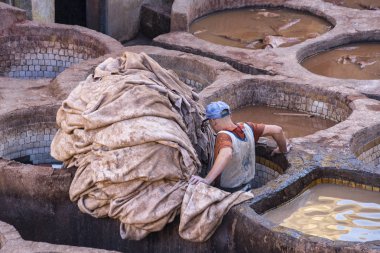 Fes, Fas - 15 Kasım 2018: boya tencere, eski Medine renkli deri Tabakhane tanner olarak çalışan adam boya su depoları ve geleneksel Tabakhane fıçılar