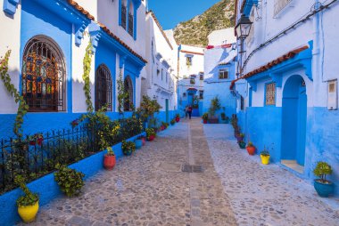 : Chefchaouen, Morocco - 17 Kasım 2018: Tanınmayan kızlar turist Chefchaouen - büyülü masal şehir Medine harika sihirli cadde boyunca yürüyüş
