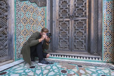 Genç Avrupalı turist ile bir fotoğraf makinesi alır medrese Bou Inania (medreseler el Bouanania) resimde Marinid mimarisinin mükemmel bir örnek kabul edilmektedir. Souk Fez Medina, Fes el Bali