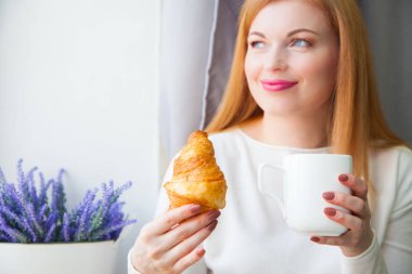 Bir kız çay içme ve pencereden dışarı bakıp