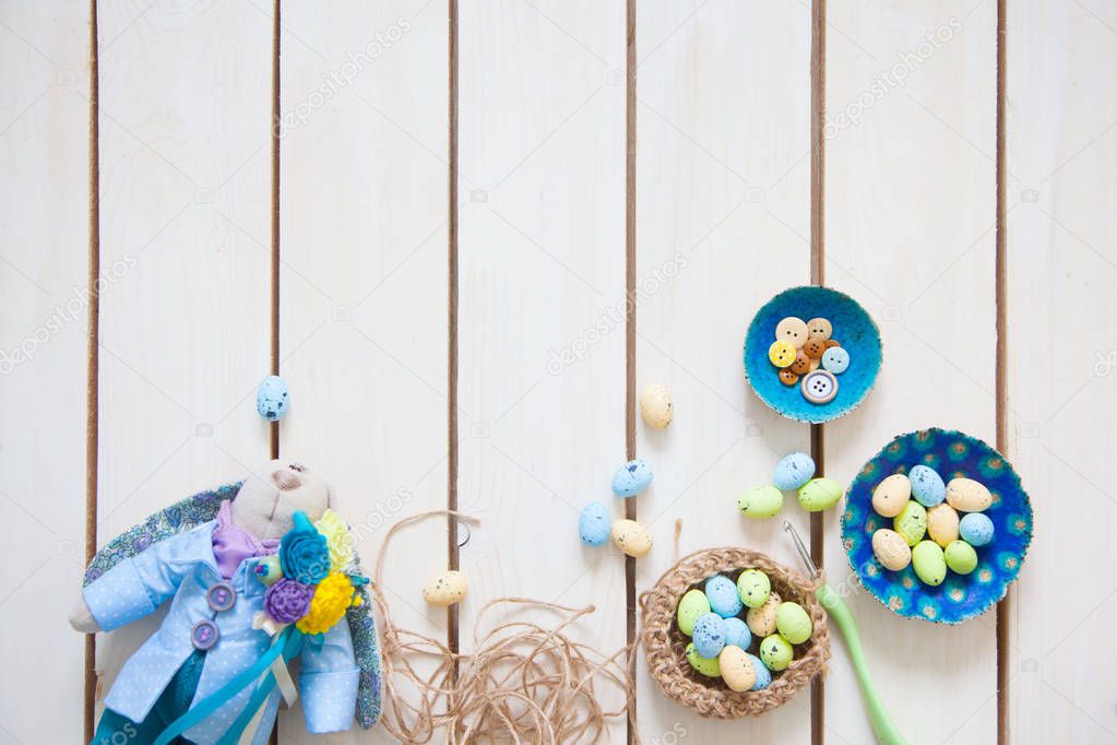 Handmade toys. Easter rabbit. Multicolored eggs. White background. Nest with eggs.