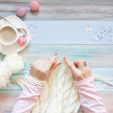 Örgü örgü iğne ile. Beyaz kumaş örme. Kahve Americano. Arka plan ışığı yaşlı.