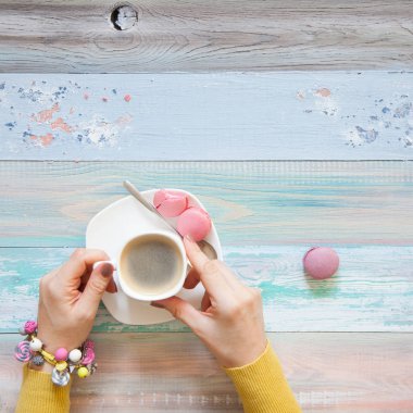 Örgü örgü iğne ile. Beyaz kumaş örme. Kahve Americano. Arka plan ışığı yaşlı.