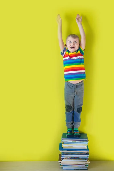 Ragazzo Piedi Sui Libri Allunga Alza Mani Sorride — Foto Stock