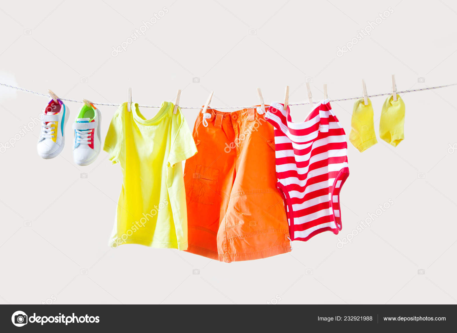 Clothesline Hanging Baby Clothes Yellow Background Stock Photo by