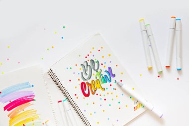 grafik tasarım, el yazısı, yaratma kavramı. ihale küçük elleri kadın ressam süs süslü harfler beyaz çizgili kağıt üzerinde keçeli kalemler ile inscribing.
