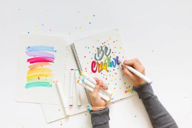 grafik tasarım, el yazısı, yaratma kavramı. ihale küçük elleri kadın ressam süs süslü harfler beyaz çizgili kağıt üzerinde keçeli kalemler ile inscribing.
