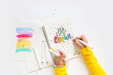 grafik tasarım, el yazısı, yaratma kavramı. ihale küçük elleri kadın ressam süs süslü harfler beyaz çizgili kağıt üzerinde keçeli kalemler ile inscribing.