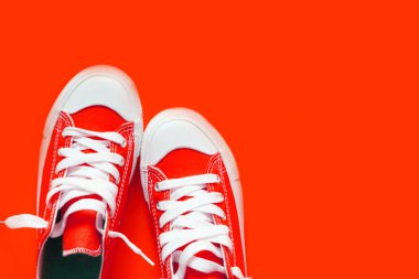 Kırmızı bir arka plan üzerinde kısa düşük parlak spor ayakkabı.