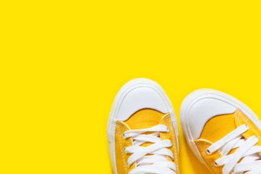 Sarı bir arka plan üzerinde kısa düşük parlak spor ayakkabı.