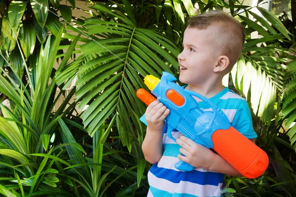 Bambino Gioca Arma Giocattolo Tropici Fogliame Alberi — Foto Stock