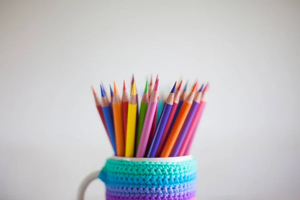 Colored pencils in a pencil case on workspace and workshop background