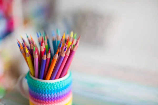 Colored pencils in a pencil case on workspace and workshop background