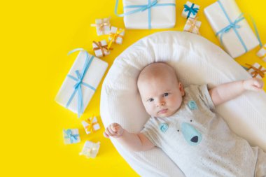Bebek giyim, banyo malzemeleri, oyuncaklar ve sağlık bakım aksesuarları ile sarı arka plan üzerinde. Liste veya genel bilgileri hamilelik ve bebek duş alışveriş diliyorum. Yukarıdan görüntüleyin. Çocuk besleme değiştirme ve banyo