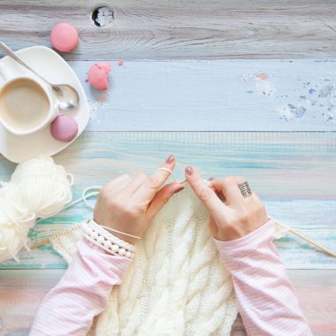 Örgü örgü iğne ile. Beyaz kumaş örme. Kahve Americano. Arka plan ışığı yaşlı.