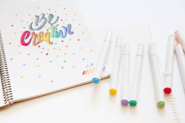 grafik tasarım, el yazısı, yaratma kavramı. ihale küçük elleri kadın ressam süs süslü harfler beyaz çizgili kağıt üzerinde keçeli kalemler ile inscribing.