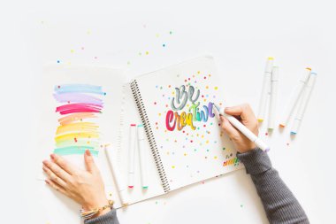 grafik tasarım, el yazısı, yaratma kavramı. ihale küçük elleri kadın ressam süs süslü harfler beyaz çizgili kağıt üzerinde keçeli kalemler ile inscribing.