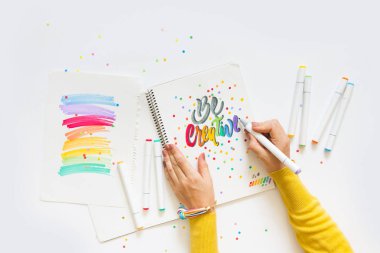 grafik tasarım, el yazısı, yaratma kavramı. ihale küçük elleri kadın ressam süs süslü harfler beyaz çizgili kağıt üzerinde keçeli kalemler ile inscribing.