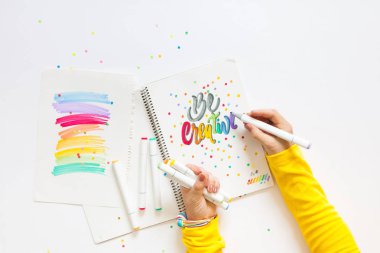 grafik tasarım, el yazısı, yaratma kavramı. ihale küçük elleri kadın ressam süs süslü harfler beyaz çizgili kağıt üzerinde keçeli kalemler ile inscribing.