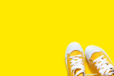 Sarı bir arka plan üzerinde kısa düşük parlak spor ayakkabı.