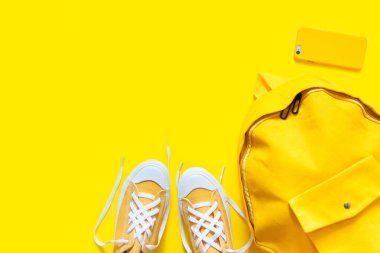 Sarı bir arka plan üzerinde kısa düşük parlak ayakkabılar. Sırt çantası, pho
