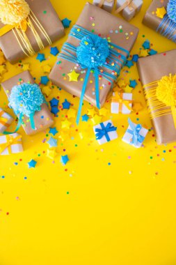 Renkli kurdeleler ve ponpon ile renkli hediye kutuları. Sarı geri