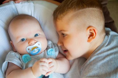 Ağabeyi görünüyor ve onun kardeşi ile oynuyor. Nötr tonları.