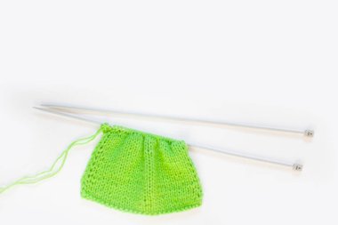 Örme kumaş yeşil ve pembe. Yeşil ve pembe örgü iplik. Beyaz arka plan.