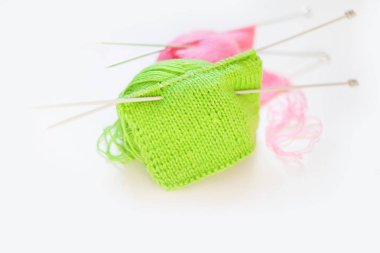 Örme kumaş yeşil ve pembe. Yeşil ve pembe örgü iplik. Beyaz arka plan.