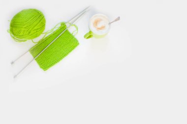 Örme örme yeşil. Yeşil örgü iplik. Beyaz arka plan. Kahve kapuçino.