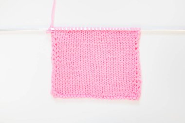 Örme kumaş pembe. Pembe örgü iplik. Beyaz arka plan.