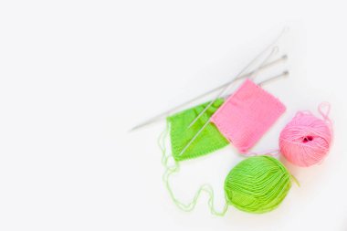 Örme kumaş yeşil ve pembe. Yeşil ve pembe örgü iplik. Beyaz arka plan.