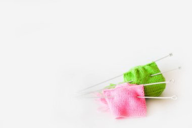 Örme kumaş yeşil ve pembe. Yeşil ve pembe örgü iplik. Beyaz arka plan.