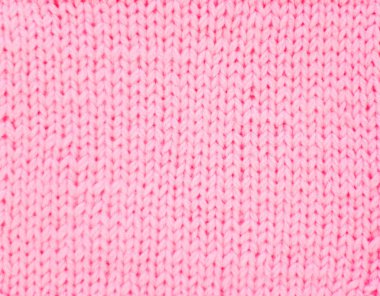 Örme kumaş pembe. Pembe örgü iplik. Beyaz arka plan.