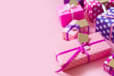 Renkli hediye kutuları renkli şeritler. Pembe bir arka plan. St. Valentine's Day veya bir doğum günü hediyesi.