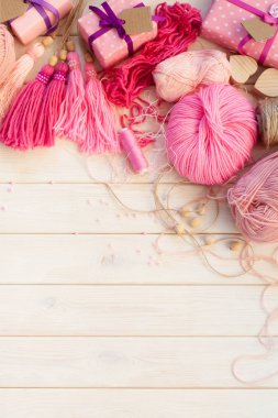 Pembe püsküllü. Beyaz ahşap arka plan. Kadın el sanatları. Yaratıcılık kavramı.