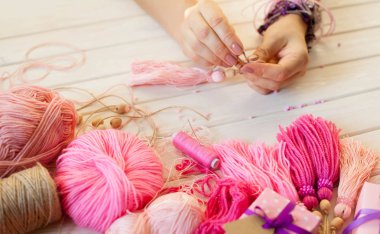 Pembe püsküllü. Beyaz ahşap arka plan. Kadın el sanatları. Yaratıcılık kavramı.