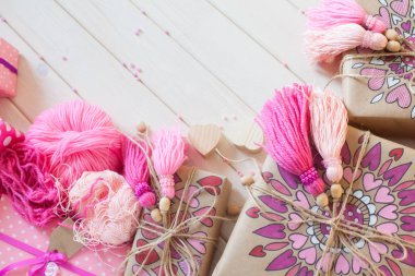 Pembe püsküllü. Beyaz ahşap arka plan. Kadın el sanatları. Yaratıcılık kavramı.