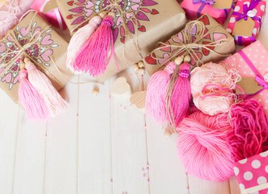 Pembe püsküllü. Beyaz ahşap arka plan. Kadın el sanatları. Yaratıcılık kavramı.