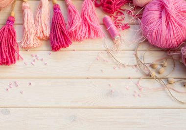 Pembe püsküllü. Beyaz ahşap arka plan. Kadın el sanatları. Yaratıcılık kavramı.